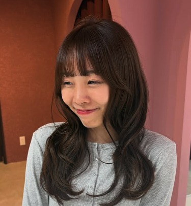 グレーのカーディガン姿ではにかむ叶愛